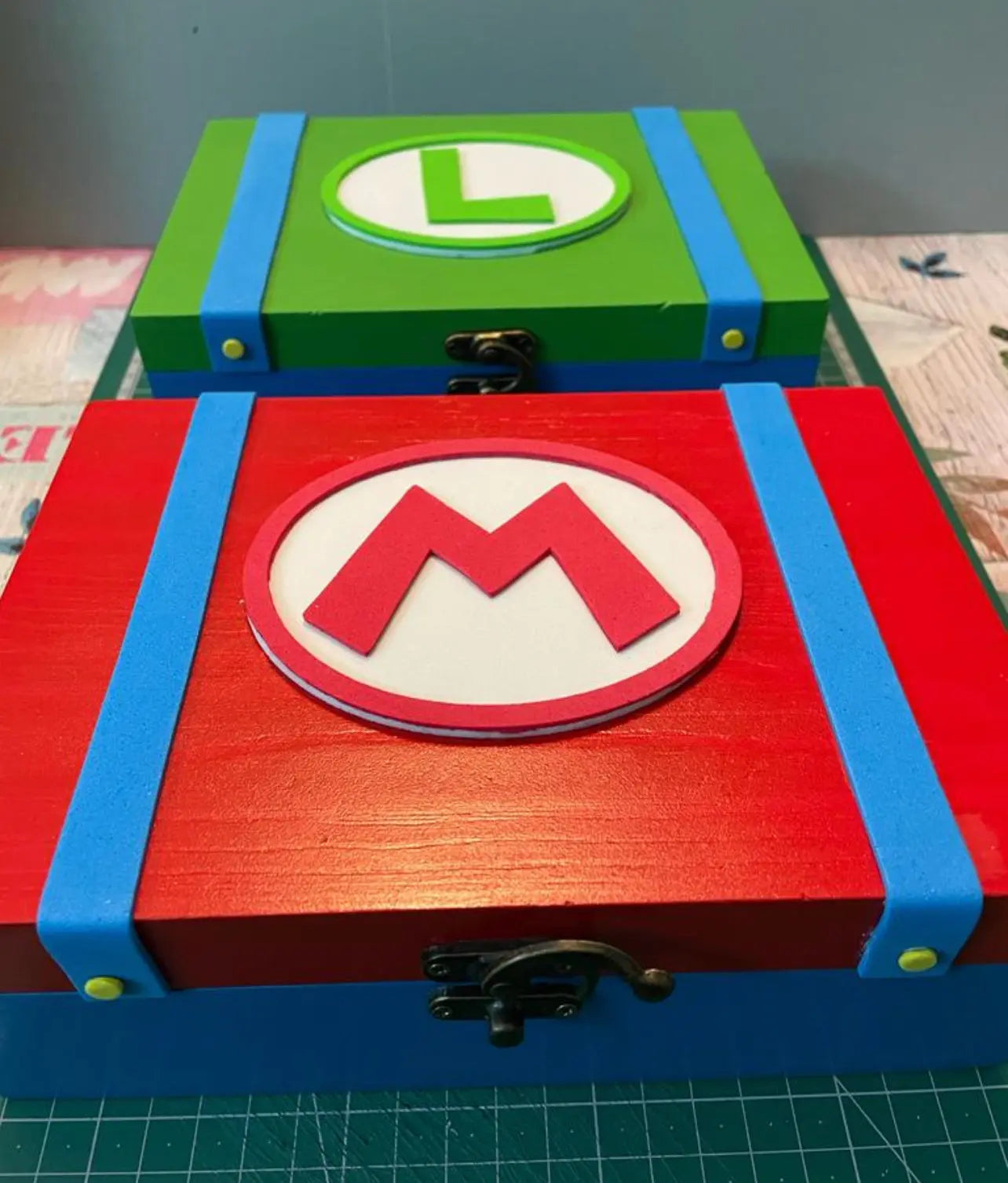 Decorative wooden Mario and Luigi storage boxes with colorful handcrafted relief designs and clasp closures.