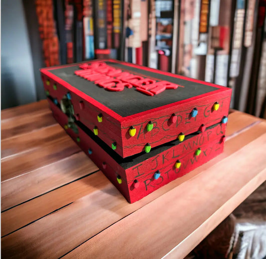 Red and black wooden decorative box inspired by Stranger Things with colorful Christmas light bulb details and embossed series logo on top.